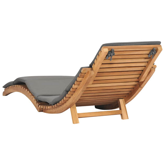 Folding sun lounger with dark cushion, made of solid teak wood, ergonomically designed for ultimate relaxation.