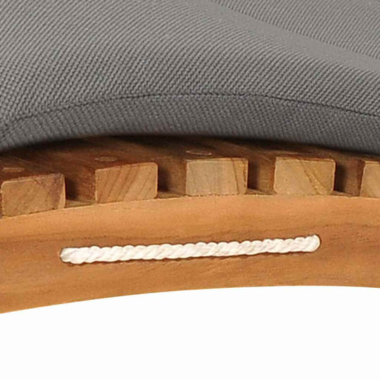 Close-up of a gray cushion on a teak wood sun lounger with a smooth finish and sturdy wooden slats.