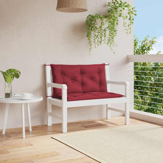 Wine garden bench cushion on white furniture, enhancing outdoor living space with comfort and style.