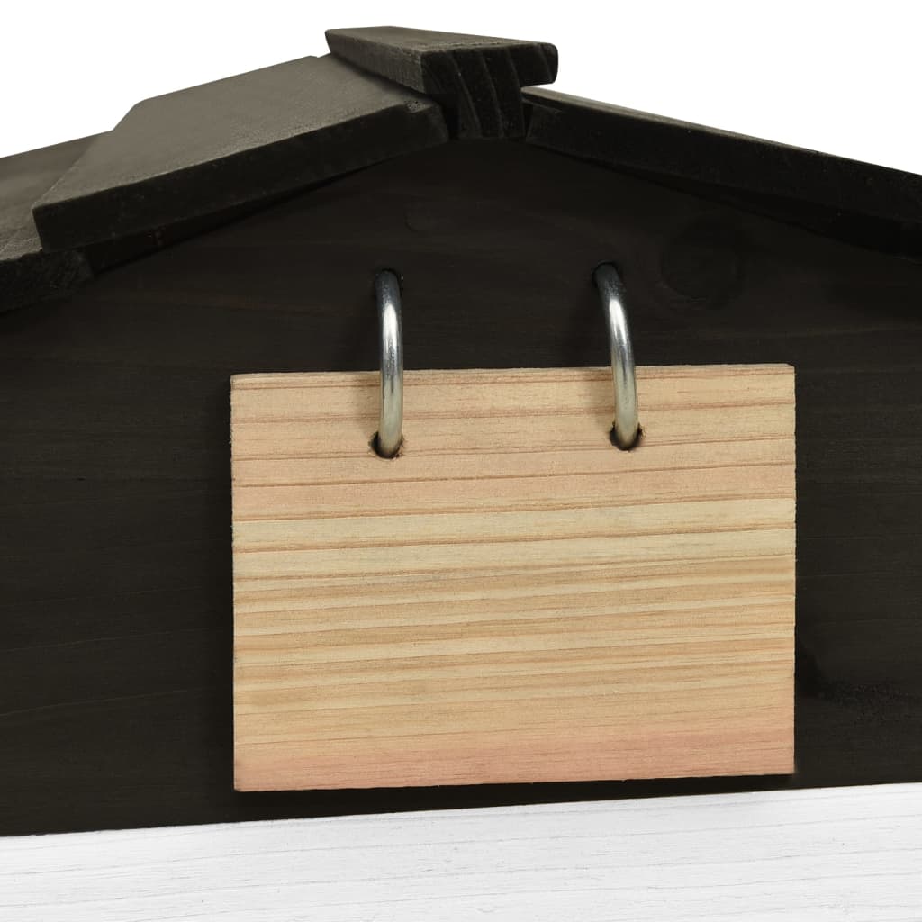 Wooden tag attached to a black and white robotic lawn mower garage, showcasing simplicity and functionality.