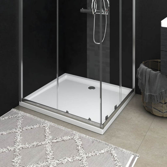 Modern white rectangular ABS shower base tray displayed in sleek bathroom setting with glass enclosure and decorative rug.