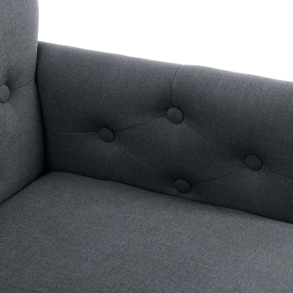 Close-up of a dark gray fabric dining chair with armrests and button tufting for added style and comfort.