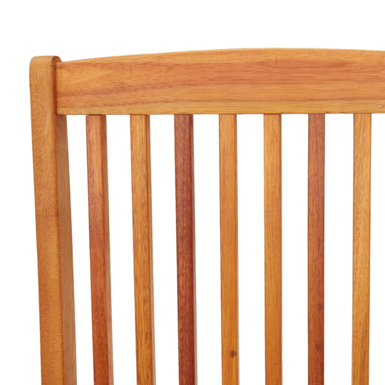 Close-up of folding garden chair backrest, showcasing solid eucalyptus wood slats in a natural finish for outdoor furniture.