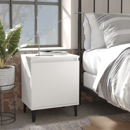 White bed cabinet with metal legs beside a bed, offering storage and modern industrial style in a cozy bedroom setting.