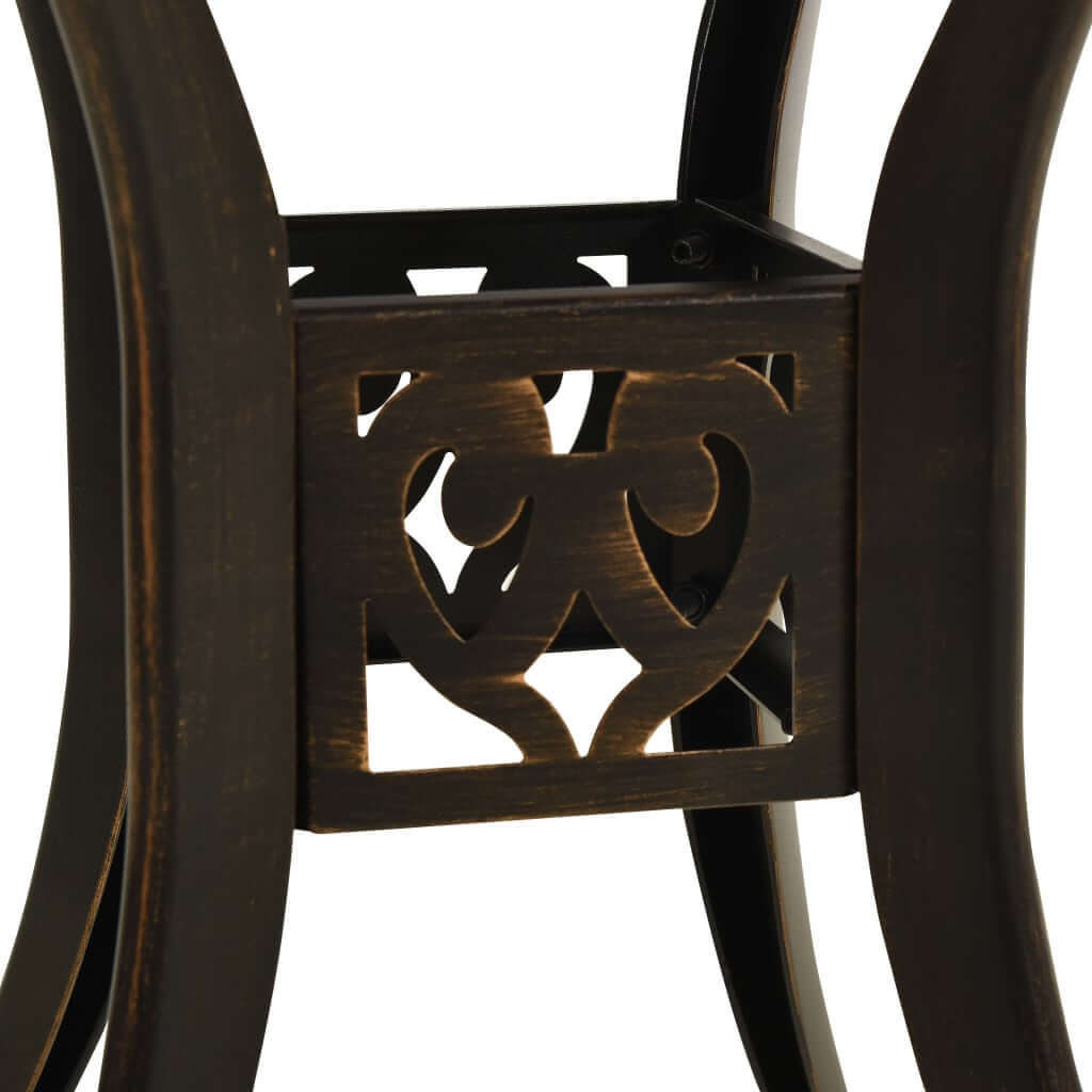 Close-up of elegant cast aluminium bistro set frame with decorative cut-out patterns in bronze finish.