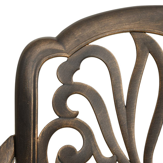 Close-up of elegant cast aluminium chair back with intricate bronze patterns for outdoor bistro set.