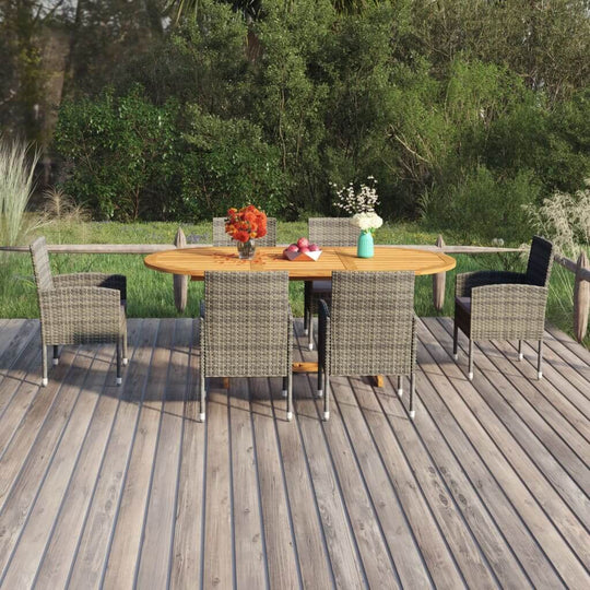 7 Piece garden dining set with acacia wood table and rattan chairs in outdoor setting surrounded by greenery.