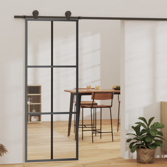 Black sliding door with ESG glass and aluminium frame, enhancing light and style in a modern interior space.