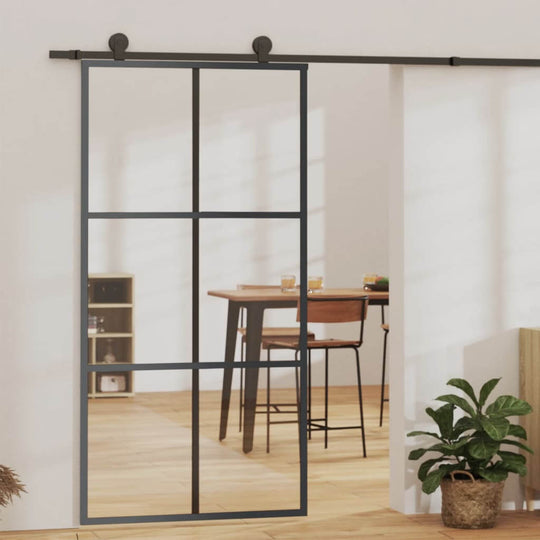 Sliding door with ESG glass and black aluminium frame, enhancing room aesthetics and natural light.