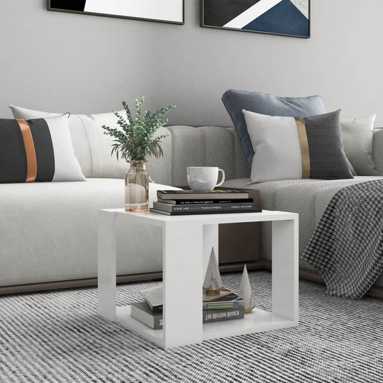 Modern white coffee table in a stylish living room setting, complementing a cozy sofa and decorative accents.