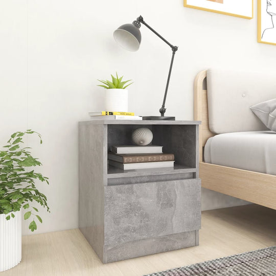 Bed cabinet in concrete grey with lamp, plants, and books, showcasing modern design and practical storage.