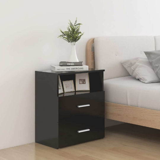 Modern black bed cabinet with two drawers and shelf, placed beside a bed in a stylish bedroom setting.