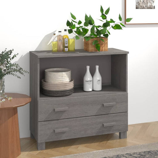 Light grey sideboard with two drawers and an open shelf displaying decorative objects and plants against a wall.