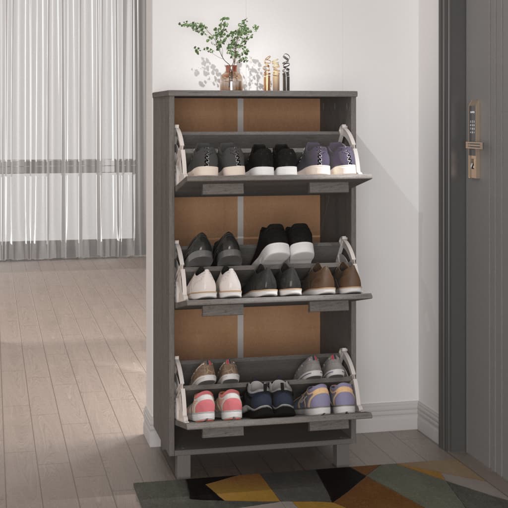 Light grey shoe cabinet with three flip-drawers holding various shoes, perfect for organized footwear storage.