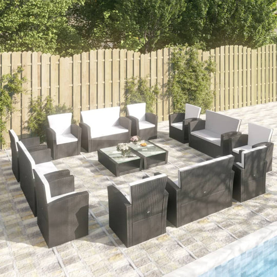 16 piece black poly rattan garden lounge set with cushions arranged around a glass table by a poolside patio.