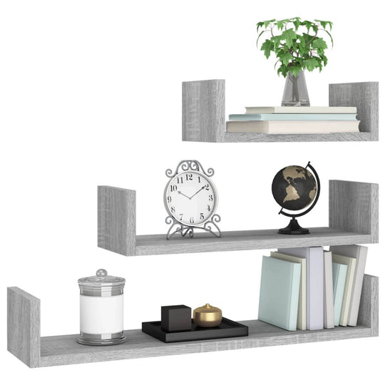 Wall display shelves in grey Sonoma wood, showcasing books, a plant, clock, globe, and decorative items.