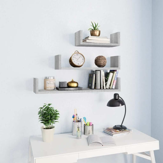 Wall display shelves in grey Sonoma engineered wood showcasing books, plants, and decorative items in a modern setting.