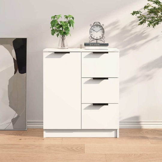 Modern white sideboard made of engineered wood with drawers, placed beside a decorative mirror and plants, enhancing room decor.