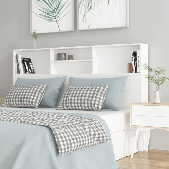 Modern white headboard cabinet with storage, cozy bedding, and decorative elements in a stylish bedroom setting.