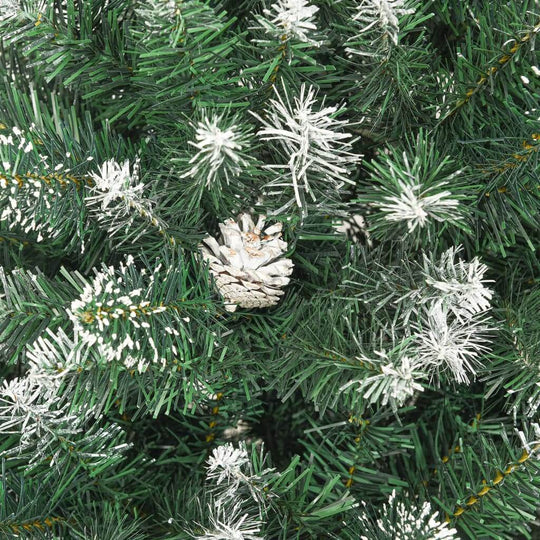 Close-up of an artificial Christmas tree featuring frosted branches and a pine cone for a festive holiday look.