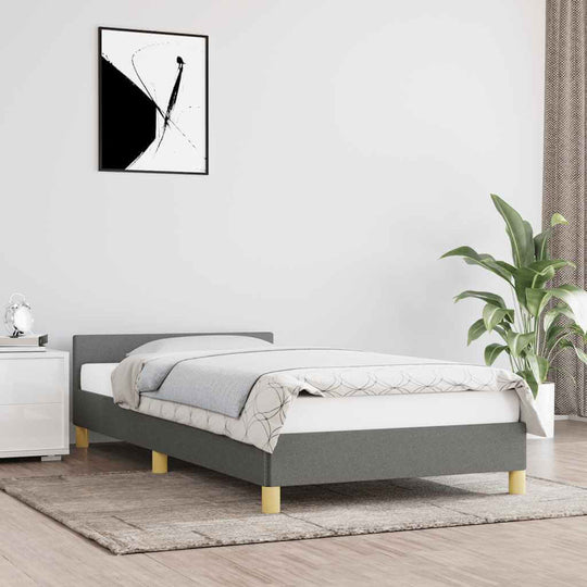 Dark grey fabric bed frame 90x200 cm with headboard and plywood slats in modern bedroom setting.