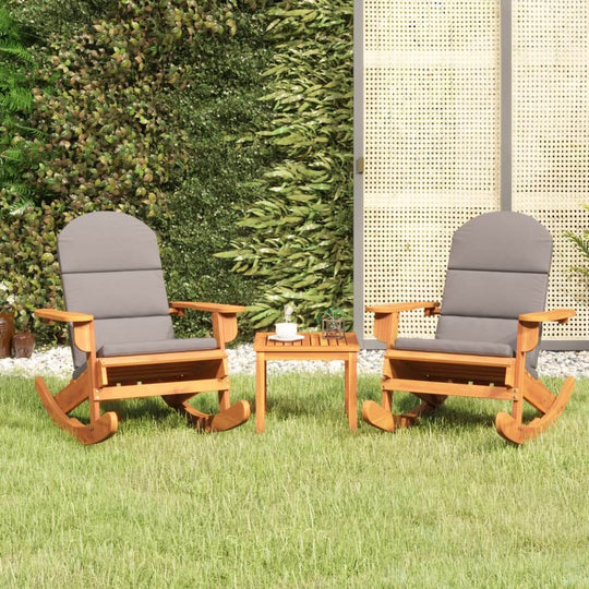 3 piece Adirondack garden lounge set with solid acacia wood rocking chairs and side table in a green outdoor setting.