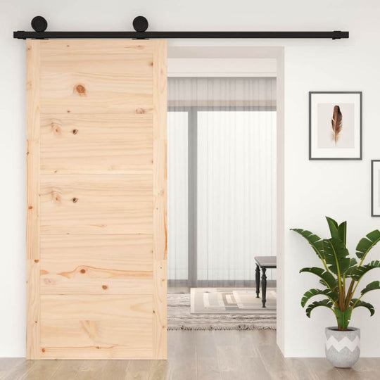 Solid wood pine barn door on a black sliding track, enhancing the interior space with a rustic charm.