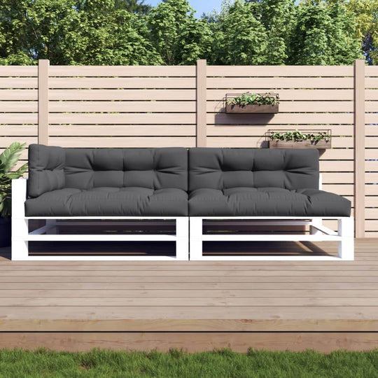 Outdoor lounge sofa with anthracite cushions on a wooden deck, surrounded by a fenced garden. Perfect for stylish outdoor furniture.