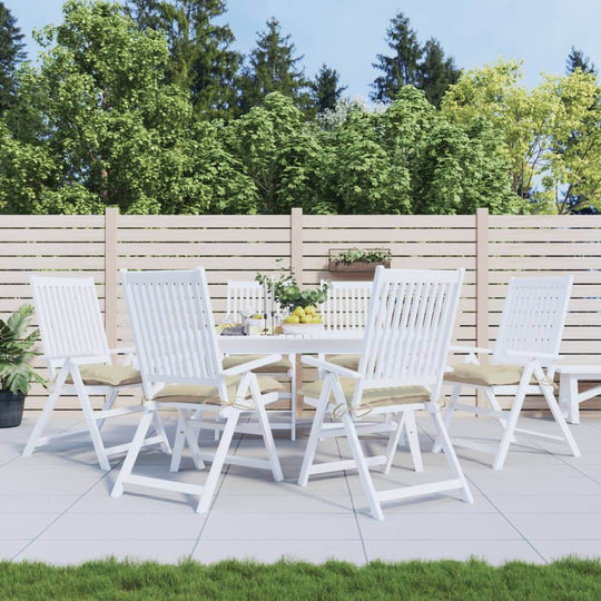 Outdoor dining set with white folding chairs and a round table, surrounded by greenery and a wooden fence. Perfect for alfresco entertaining.