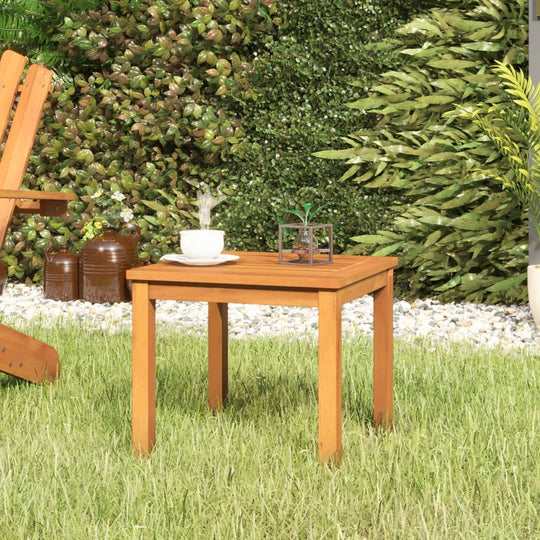 Stylish acacia wood coffee table in a garden setting, perfect for outdoor furniture and lounge areas.