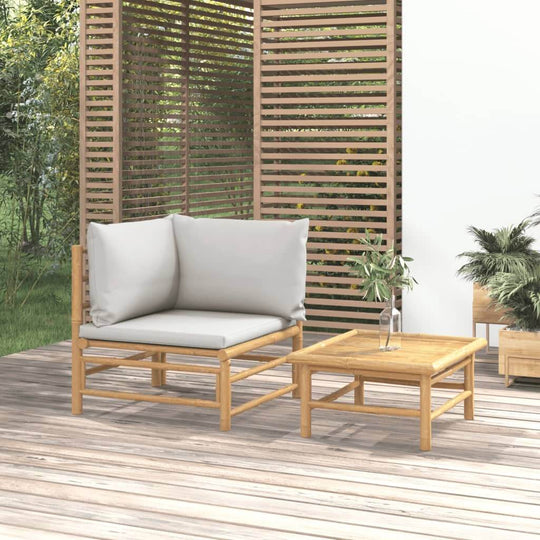 Elegant 2 piece bamboo garden lounge set with light grey cushions on a wooden deck. Perfect for outdoor relaxation.