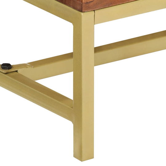 Close-up of gold metal legs supporting a solid wood tabletop, showcasing sturdy design and vintage style.