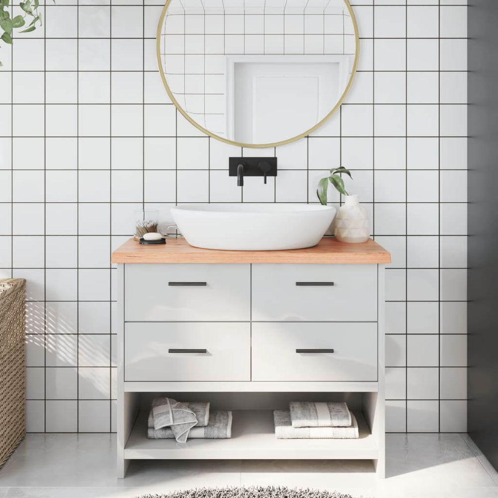 Modern bathroom vanity with light brown wooden countertop, white basin, and stylish storage drawers against tiled wall.