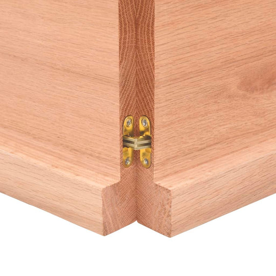 Close-up of a wooden countertop corner with gold hinge detail, showcasing solid wood construction and natural finish.