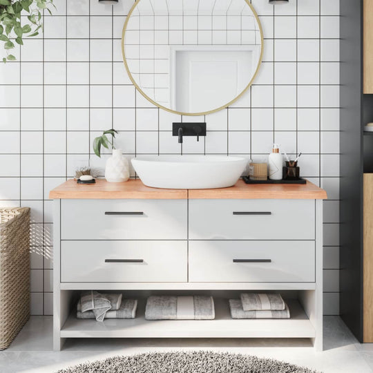 Modern bathroom with light brown countertop, round mirror, and stylish storage drawers, featuring elegant decor elements.