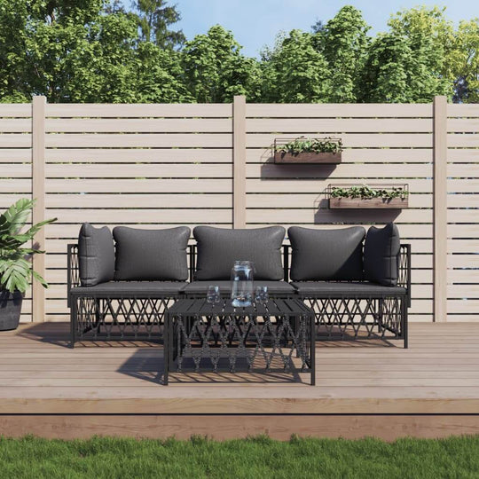 4 piece garden lounge set with cushions on a wooden deck, featuring black woven fabric and a sturdy steel frame.