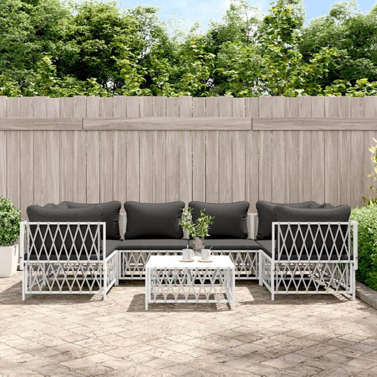 7 piece outdoor lounge set with black cushions and white steel frame in a garden setting, perfect for relaxing.