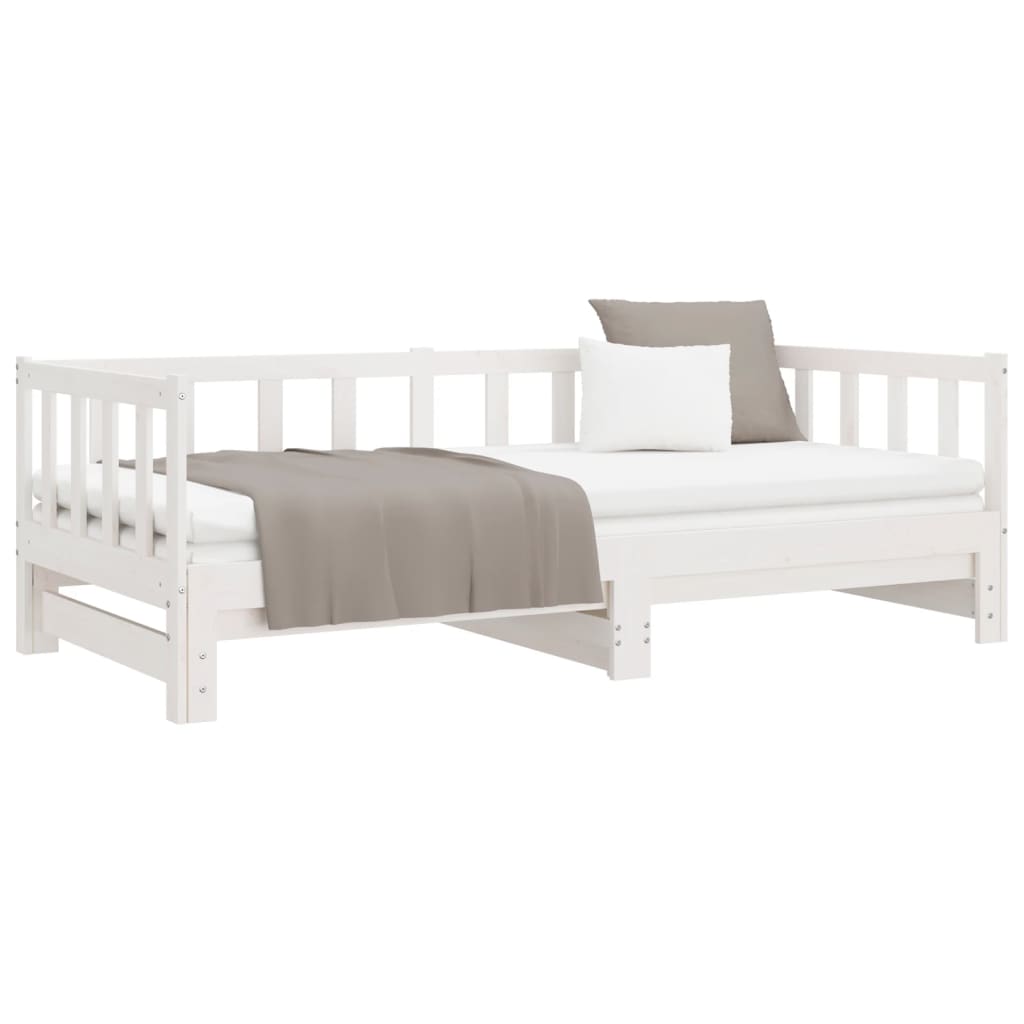 Versatile pull-out day bed in white finish, made of solid pine, suitable for bedroom or living room use, with cushions and blanket.