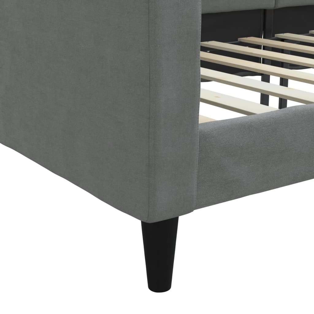 Close-up of dark grey fabric day bed corner, showcasing wooden slats and sleek black legs, perfect for versatile furniture use.