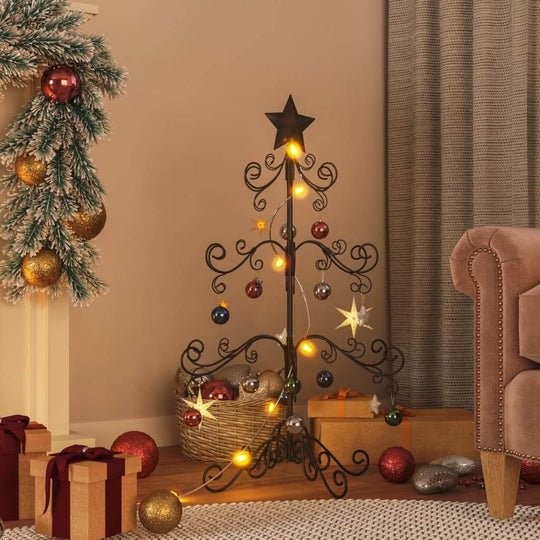 Elegant black metal Christmas tree decorated with lights and ornaments in a cozy living room setting.