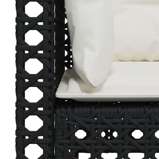 Close-up of a black poly rattan garden sofa with a white cushion, highlighting its durable woven texture and comfort.