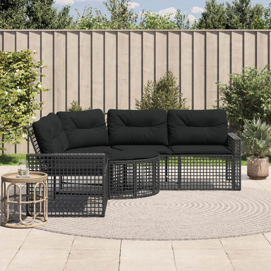 L-shaped black poly rattan garden sofa with cushions and footstool, perfect for outdoor lounging and relaxation.