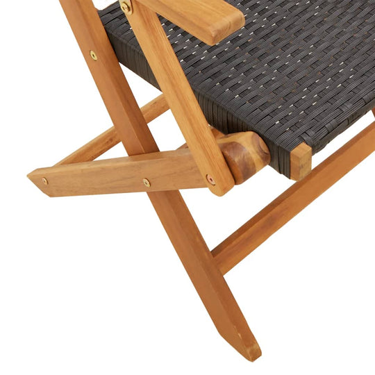 Folding garden chair with black poly rattan seating and solid acacia wood frame, ideal for outdoor furniture use.