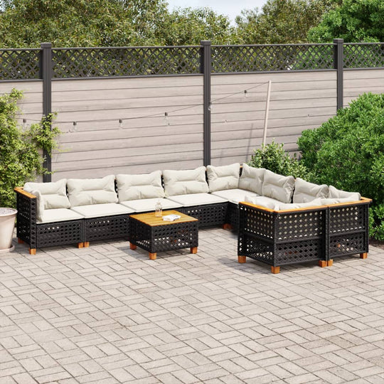 Black poly rattan 10 piece garden sofa set with cushions on a patio, featuring a coffee table and lush greenery in the background.