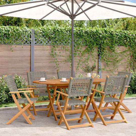 7 piece garden dining set featuring grey poly rattan chairs and solid acacia wood table under an umbrella in a lush outdoor setting.